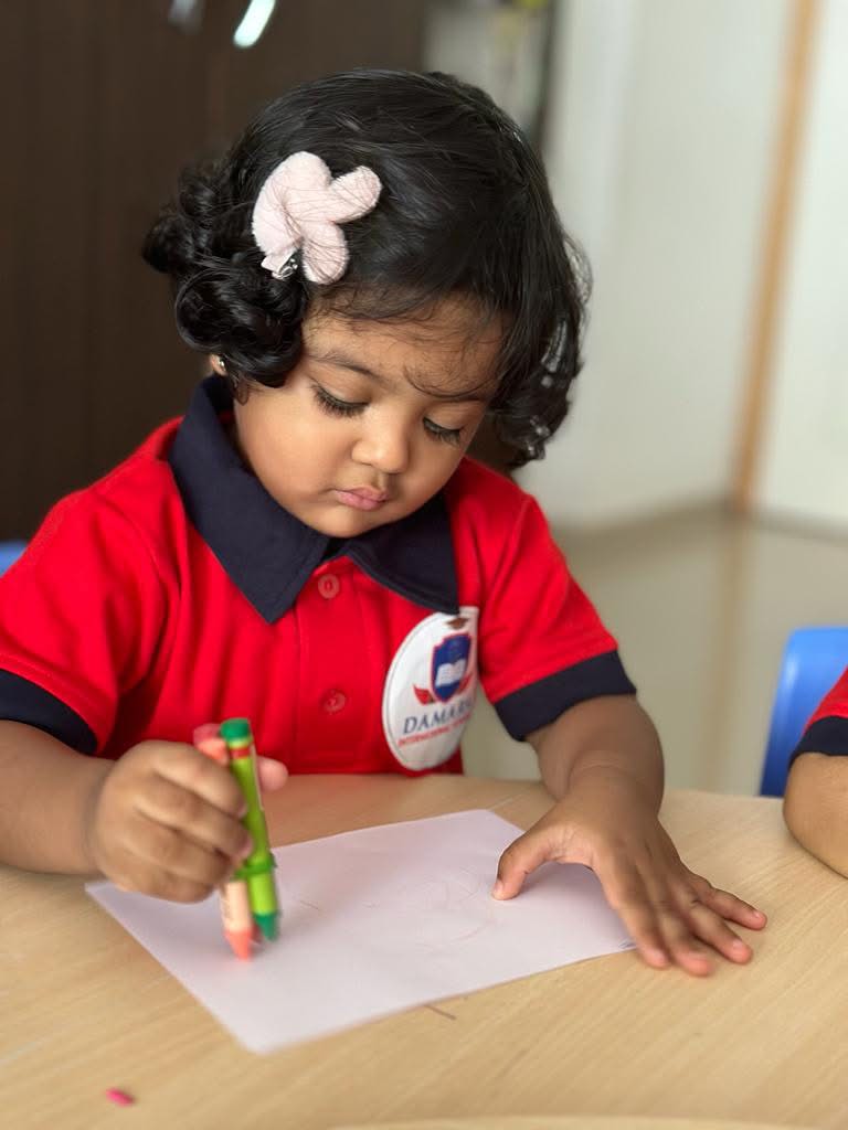 Preschool child exploring sensory garden plants at Damara Koregaon Park campus